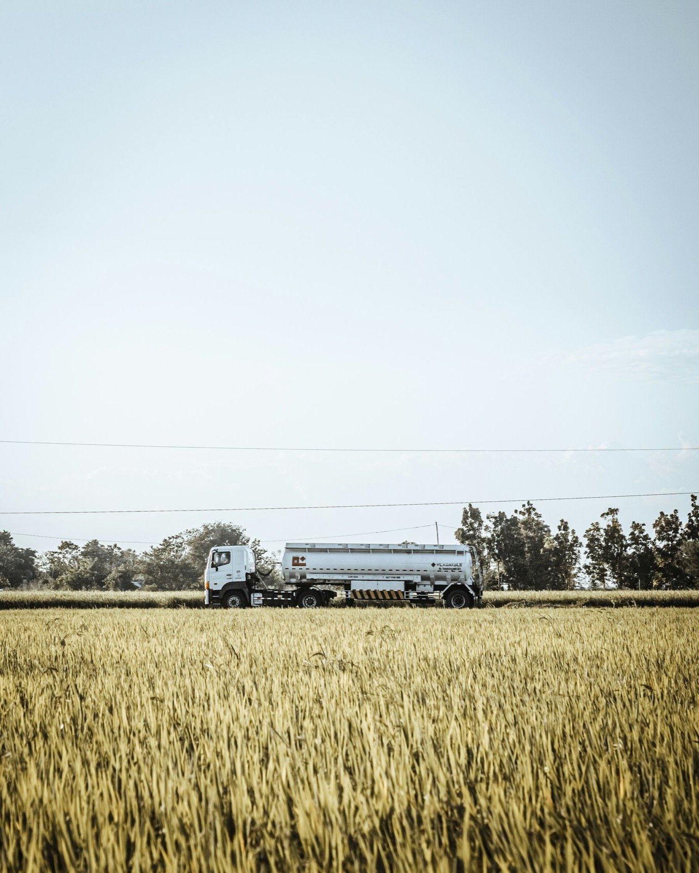 Autotanque de combustible junto a un campo de cultivo